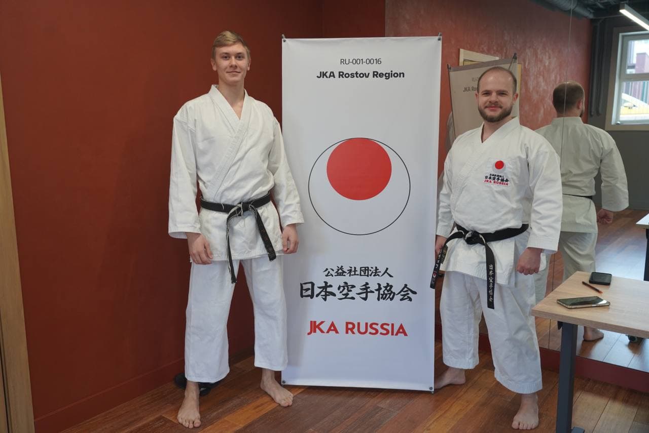 Два тренера в кимоно у баннера JKA Rostov Region