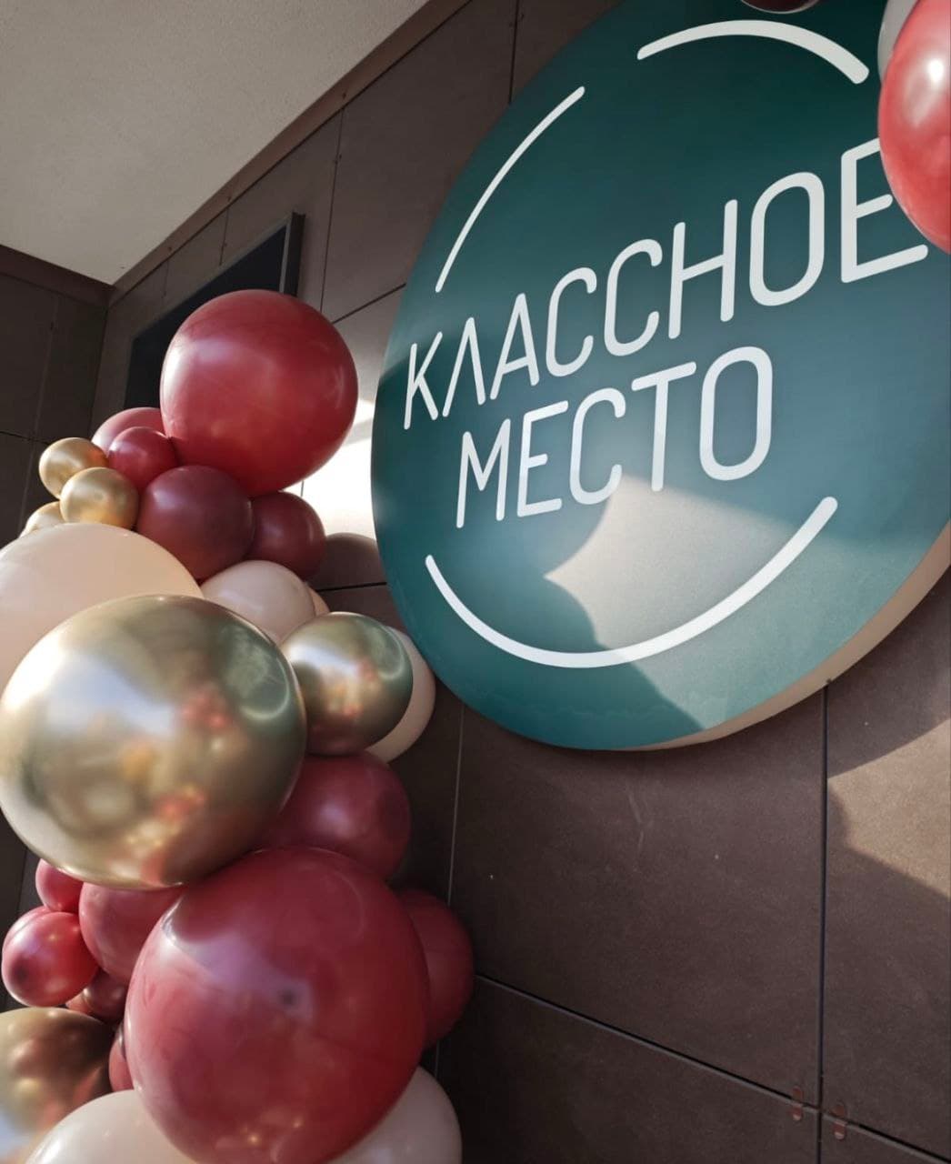Вывеска «Классное место» с воздушными шарами у входа